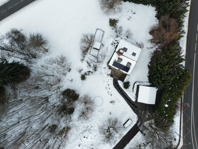 Vue aérienne d'une maison sous la neige, prise par drone